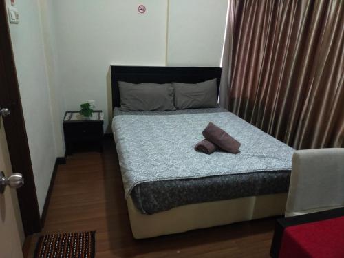 马六甲Bayou lagoon Muslim Apartment的小卧室配有带枕头的床