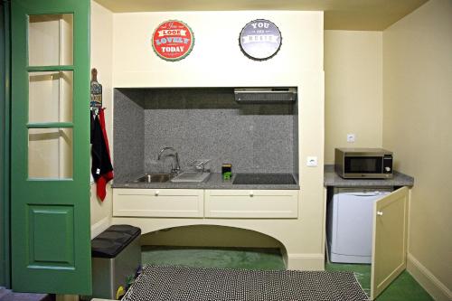 丰沙尔29 Madeira Hostel的一间带水槽和微波炉的小厨房