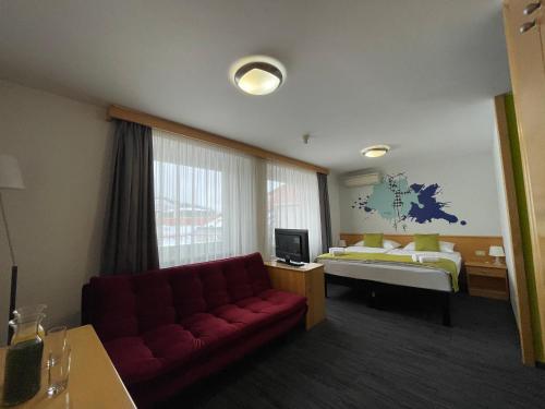 马里博尔Hotel Orel的酒店客房设有一张沙发和一张床