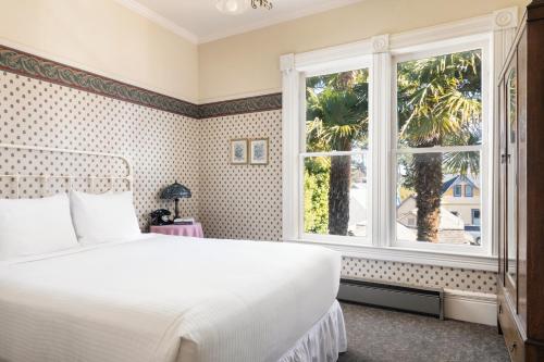 太平洋丛林Centrella Hotel, a Kirkwood Collection Hotel的卧室配有白色的床和窗户。