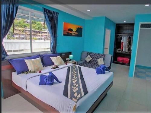 芭东海滩PATONG BLUE HOTEL的一间卧室设有两张床和蓝色的墙壁