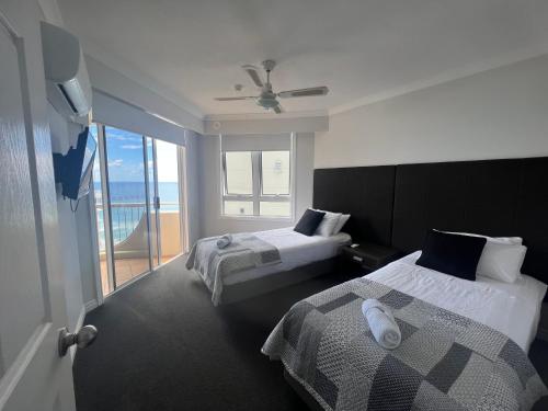 黄金海岸Stunning 2 bedroom Ocean View Apartment的酒店客房设有两张床和一个阳台。