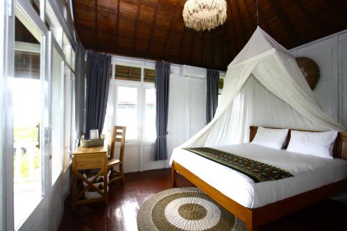 LabuberuPASERANG PARIRI PARADISE的一间卧室配有一张带蚊帐的床