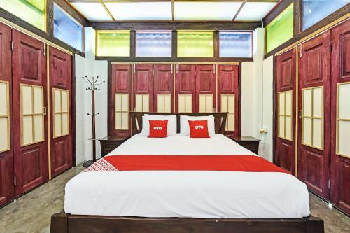 小笨珍OYO Home 90332 Jentayu Homestay Pontian的一间卧室配有一张带红色枕头的大床