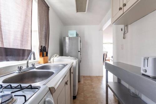墨西哥城Condesa, Depto 2 recamaras.的厨房配有水槽和不锈钢冰箱