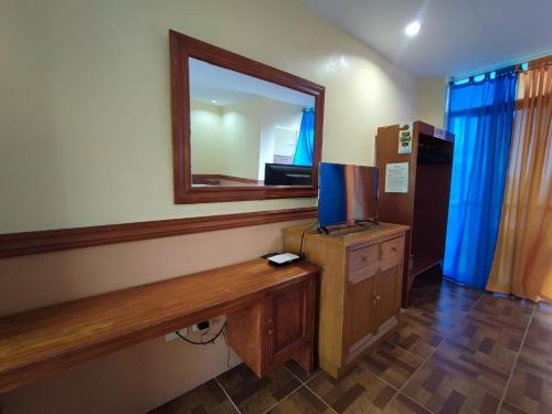SibulanSea Forest Resort的一间设有镜子和桌子上的电视的房间
