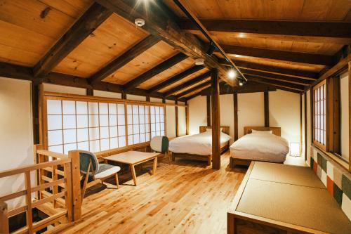 古川町SATOYAMA STAY Nino-Machi的一间设有两张床和一张桌子的房间