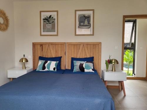 格兰贝伊Villa de Luxe à Grand Baie avec piscine V12的一间卧室配有蓝色的床和2个床头柜