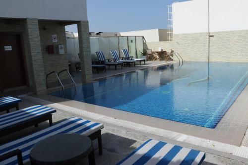 多哈雷托尤酒店的一个带蓝白条纹椅子的大型游泳池