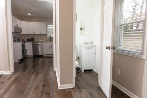罗阿诺Newly renovated home less than a mile from downtown Roanoke的厨房铺有木地板,配有白色橱柜。