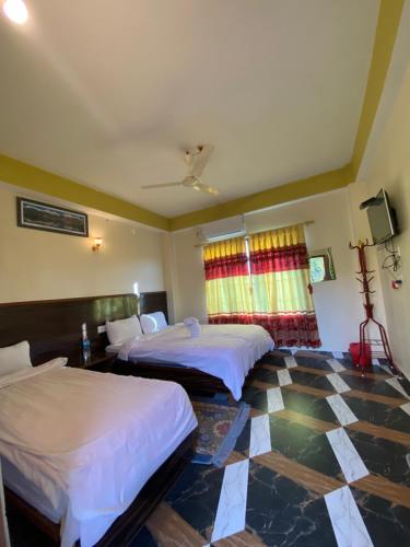奇旺Hotel Greenlight的酒店客房,设有两张床,铺有瓷砖地板。