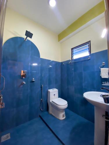 奇旺Hotel Greenlight的蓝色的浴室设有卫生间和水槽