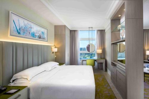 阿布扎比洛塔纳全套房酒店的卧室配有一张白色大床和一张书桌