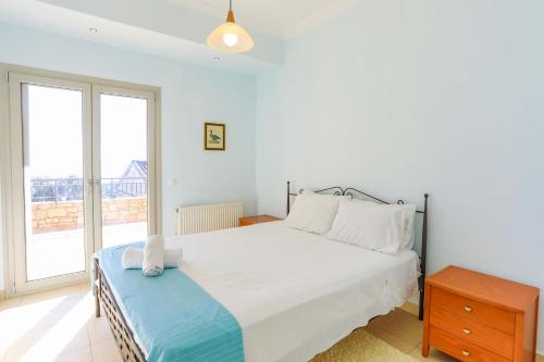 卡拉米Villa Kalamia的卧室设有白色的床和大窗户