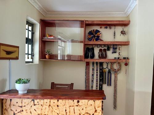 OlolaimutiekMasai Heritage Guesthouse的一间设有木桌和有领带的架子的房间