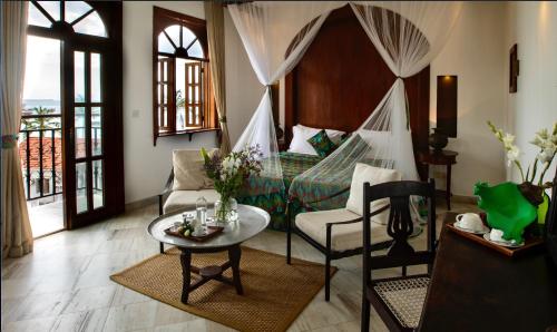 桑给巴尔赛伊达温泉酒店 的客厅配有床和桌椅