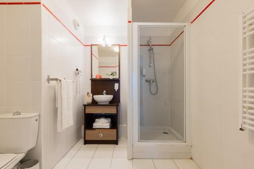 马尼·莱斯·阿莫Zenitude Hôtel-Résidences Magny-les-Hameaux的带淋浴、卫生间和盥洗盆的浴室