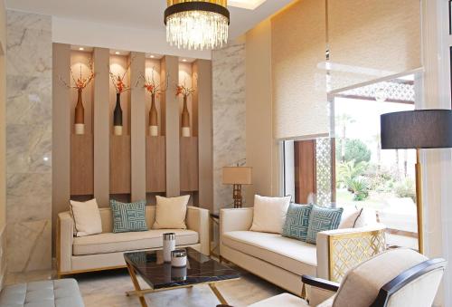卡尔维Hotel Corsica & Spa Serena的客厅配有两张沙发和一个吊灯。
