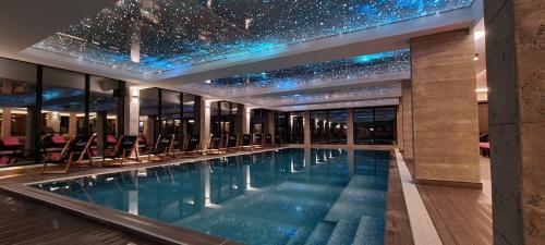 科帕奥尼克Apartmani Srna Milmari的一座拥有星空天花板的建筑中的游泳池