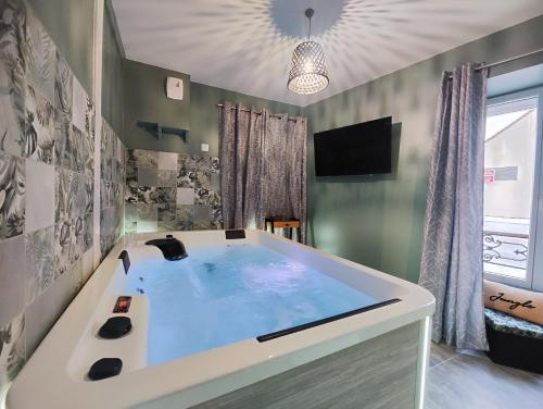 Chaumes-en-BrieJacuzzi privatif - Suite Amazonie - 1 ou 2 chambres的带电视的客房内的大浴缸