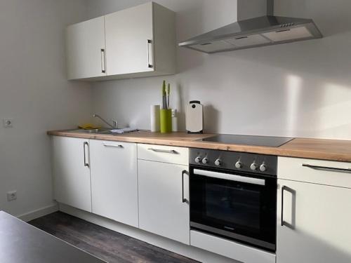 明斯特旅行公寓的厨房配有白色橱柜和黑烤箱。