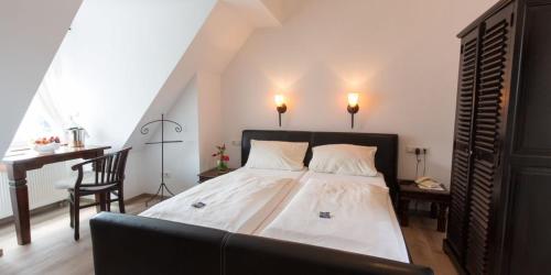 新维德Hotel zur Römerbrücke的一间卧室配有一张床、一张桌子和一把椅子