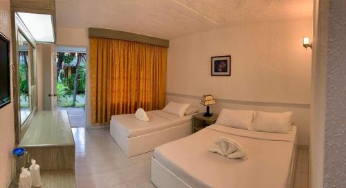 长滩岛卡萨皮拉尔海滩度假酒店的酒店客房设有两张床和窗户。