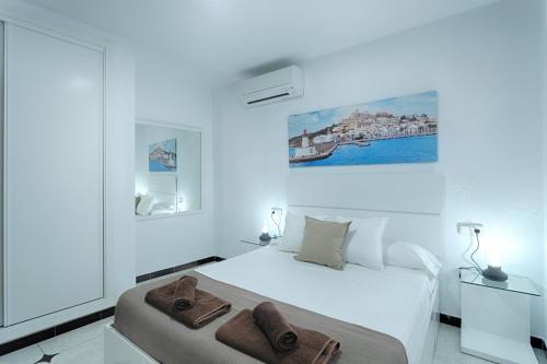 伊维萨镇Villa Simona Ibiza的白色卧室,配有带毛巾的床