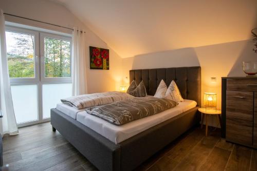 Rödental老磨坊餐厅酒店的一间卧室设有一张大床和大窗户