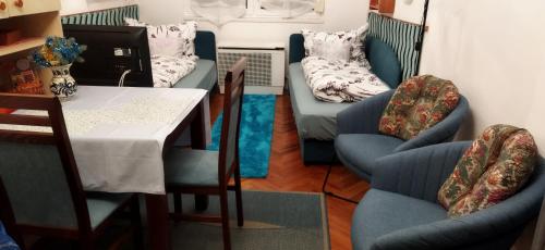 比克Adikati Lak的客厅配有两把椅子、一张桌子和一张沙发