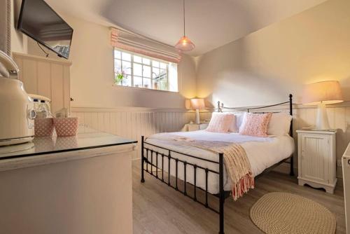 邓尼奇邓尼奇船舶旅馆的一间卧室配有带粉红色枕头的床。