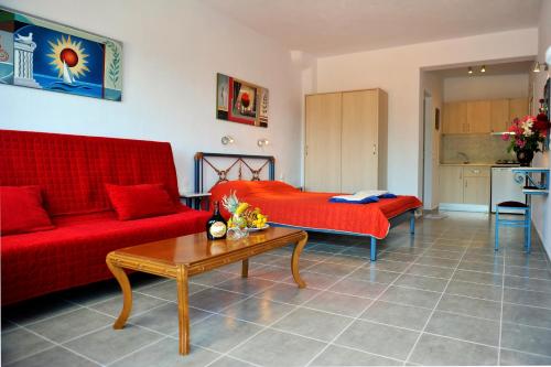 梅加利阿莫斯芬格罗斯村酒店的客厅配有红色的沙发和桌子