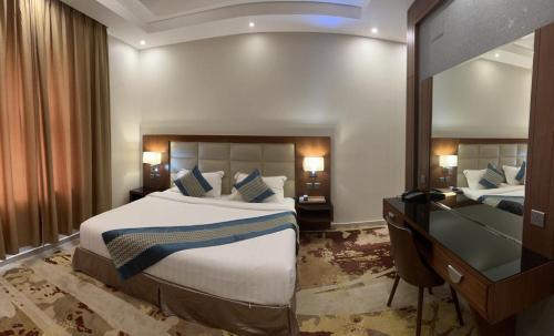 吉赞Delta Hotel Suites的酒店客房设有一张大床和一张书桌。