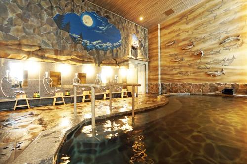札幌北海道札幌大通柔婕阁酒店的一个带岩石墙的房间的游泳池