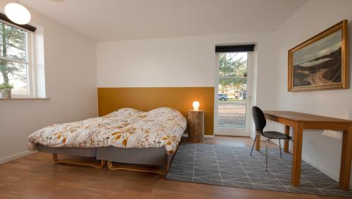 TjæreborgGuesthouse Tradsborgvej的一间卧室配有一张床、一张桌子和一张书桌