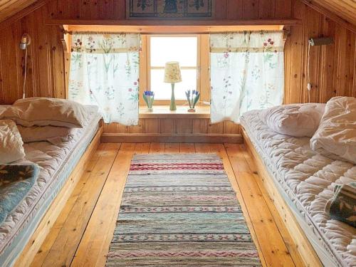 塔尔伯格Holiday home Tällberg II的配有窗户和地毯的客房内的两张床