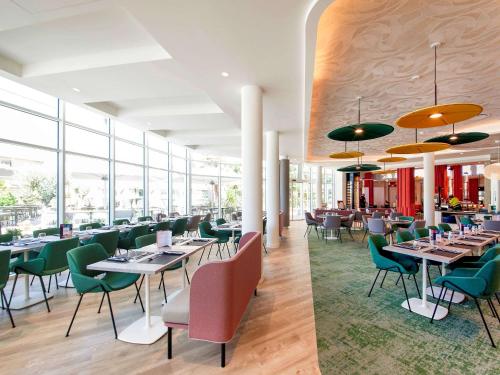 克莱蒙费朗克莱蒙费朗诺富特酒店的餐厅设有桌椅和窗户。