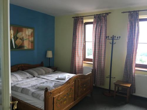 PřimdaHorský Hotel Kolowrat的一间卧室配有一张蓝色墙壁和窗户的床