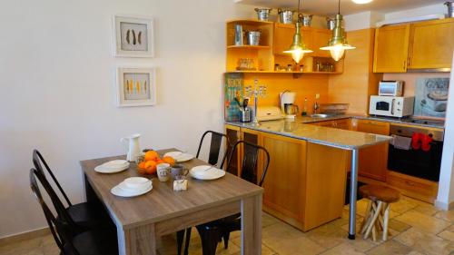 托波拉Apartment DECORA Sea View的一间带木桌的厨房和一间餐厅