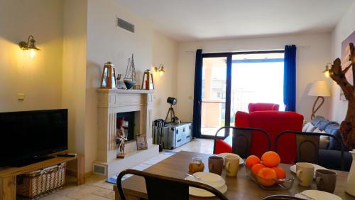托波拉Apartment DECORA Sea View的一间带桌子和电视的客厅以及一间带壁炉的房间。