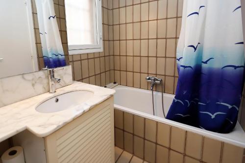 托里代巴拉AT070 Platja的浴室配有水槽、浴缸和淋浴帘