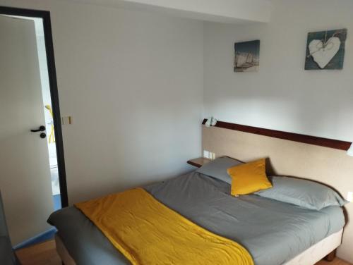 佩罗斯-吉雷克L'Albatros的一间卧室配有一张黄色枕头的床