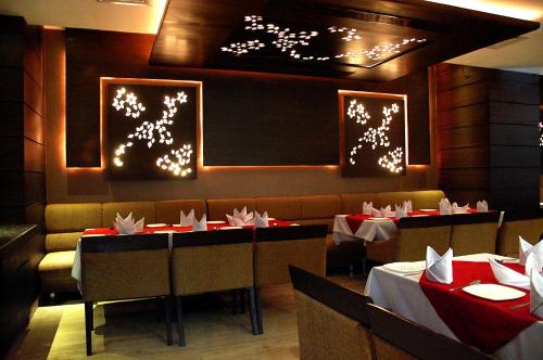 杜尔格HOTEL GARNET的一间用餐室,配有两张桌子和一个带红白桌布的展台