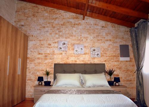 拉夫里翁Harmony的一间卧室设有砖墙和一张床