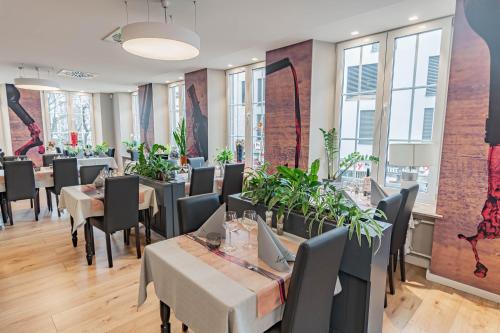 埃特尔布吕克赫克曼酒店的用餐室设有桌椅和窗户。