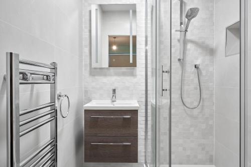 都柏林Luxury Apartment near O'Connell Street的带淋浴、盥洗盆和镜子的浴室