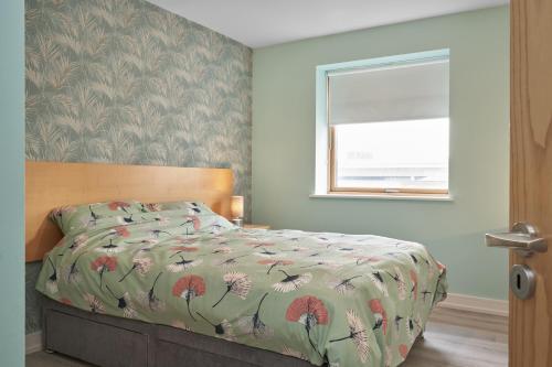 都柏林Luxury Apartment near O'Connell Street的一间卧室配有一张带床罩的床和窗户
