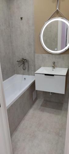 阿拉木图Квартира的带浴缸、水槽和镜子的浴室