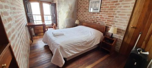 阿雷基帕La Casa de Margott的一间卧室设有一张床和砖墙