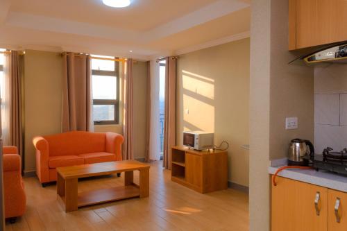 基加利Tropical Plaza Apartments的客厅配有沙发、椅子和桌子
